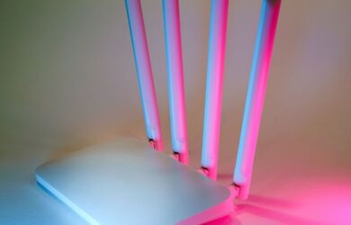 Vit wifi-router med fyra antenner belyst i rosa och blått
